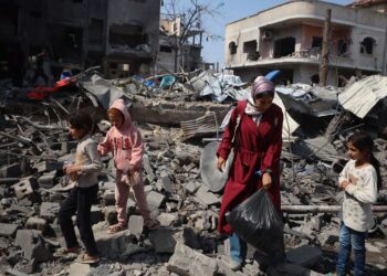 A family in Gaza looks through the rubble of a destroyed building. (Photo UNFPA)